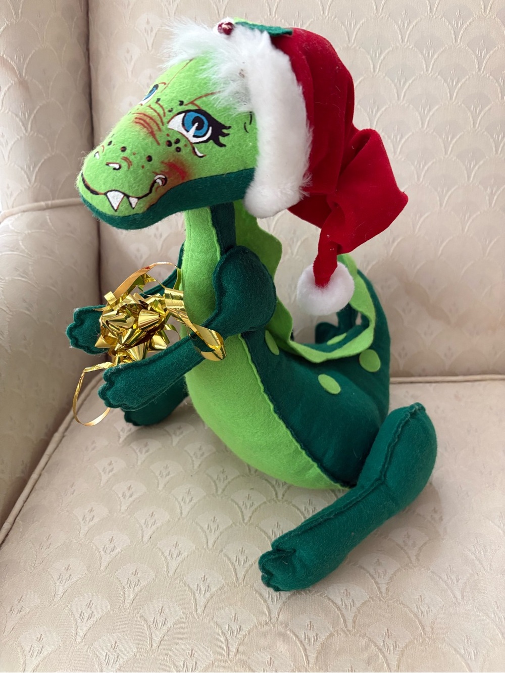 Annalee Christmas Dinosaur Doll holding a bow and wearing a Santa Hat. 2006